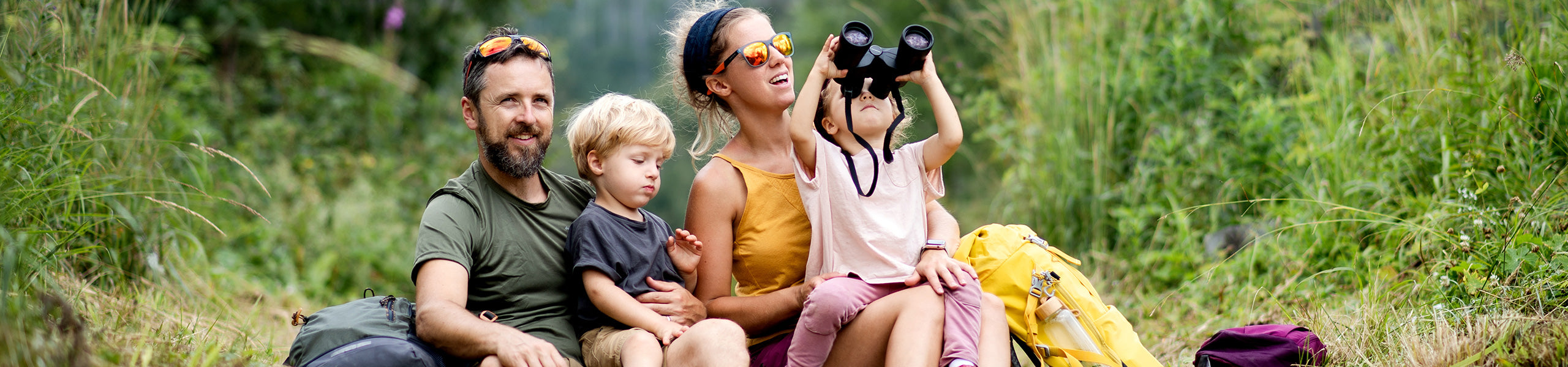 Eine Familie die in der Natur sitzt und beim wandern sind.